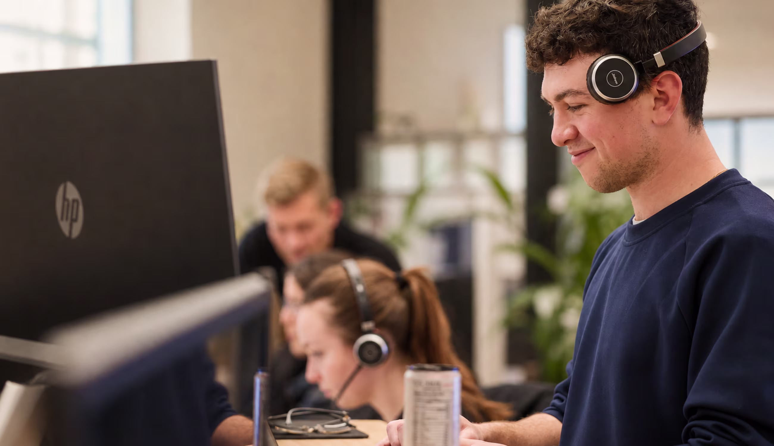 An EliseAI colleague working at a desk with headphones